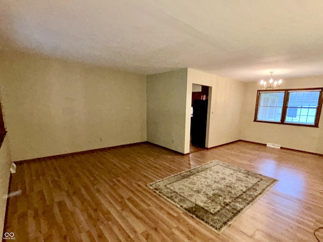 7721 Hollybrook Ln, Indianapolis, IN 46227 - empty room with wood finished floors and a chandelier