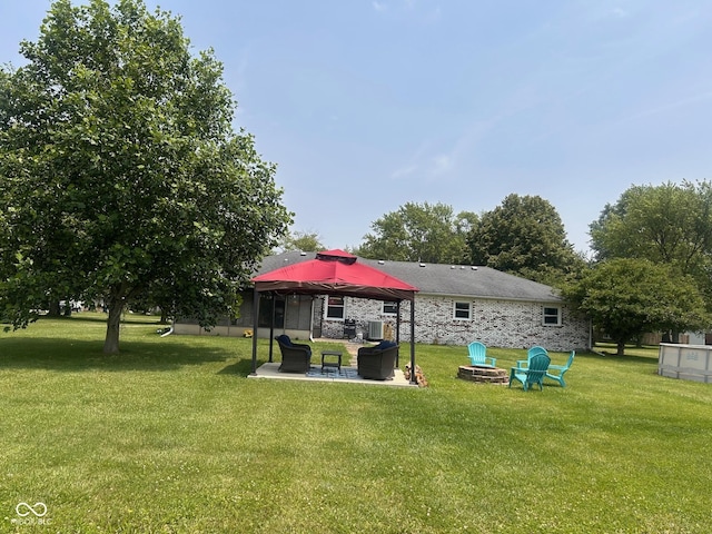 2213 Holden Dr, Anderson, IN 46012 - back of house featuring a yard, a patio, and stone siding