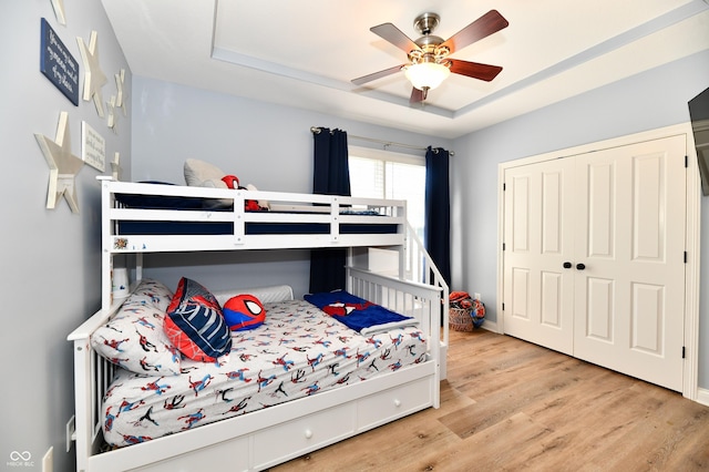 7413 Misty Woods Ln, Indianapolis, IN 46237 - bedroom with a tray ceiling, wood finished floors, a closet, and ceiling fan