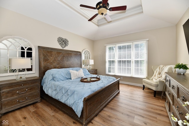 7413 Misty Woods Ln, Indianapolis, IN 46237 - bedroom with a tray ceiling, light wood-style flooring, ceiling fan, and ornamental molding