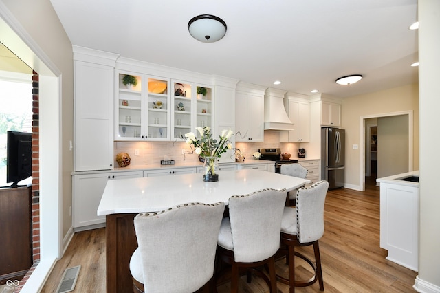 7413 Misty Woods Ln, Indianapolis, IN 46237 - kitchen with stainless steel appliances, custom exhaust hood, tasteful backsplash, white cabinetry, and recessed lighting