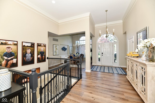 7413 Misty Woods Ln, Indianapolis, IN 46237 - entryway featuring light wood finished floors, crown molding, a chandelier, and a towering ceiling