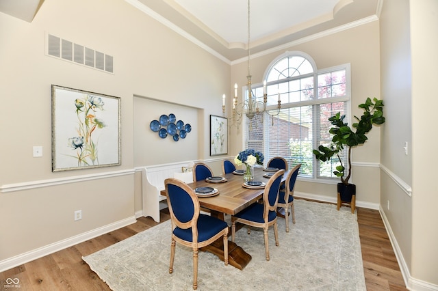 7413 Misty Woods Ln, Indianapolis, IN 46237 - dining area featuring wood finished floors, a towering ceiling, ornamental molding, and a chandelier