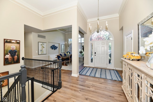 7413 Misty Woods Ln, Indianapolis, IN 46237 - entryway with a chandelier, light wood-style floors, ornamental molding, and a towering ceiling