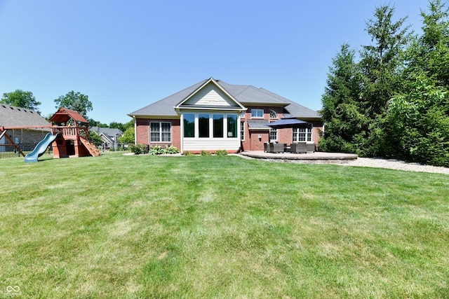 7413 Misty Woods Ln, Indianapolis, IN 46237 - back of house with a playground, a patio area, brick siding, and a yard