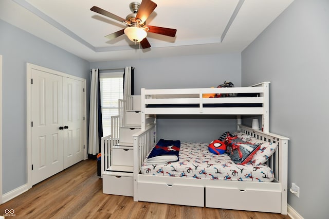 7413 Misty Woods Ln, Indianapolis, IN 46237 - bedroom with wood finished floors, a raised ceiling, a closet, and ceiling fan