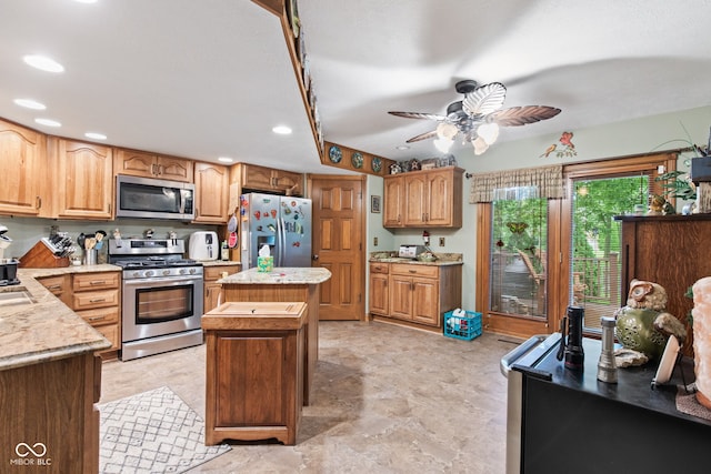 6980 White Oak Dr, Avon, IN 46123 - kitchen featuring appliances with stainless steel finishes, a center island, ceiling fan, recessed lighting, and light stone counters