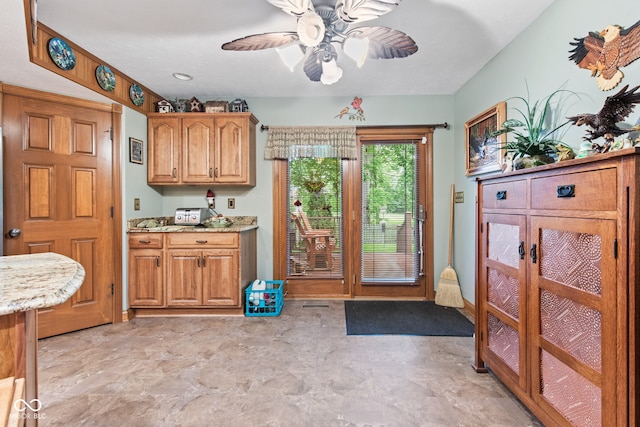 6980 White Oak Dr, Avon, IN 46123 - kitchen featuring a ceiling fan, light stone countertops, and brown cabinets