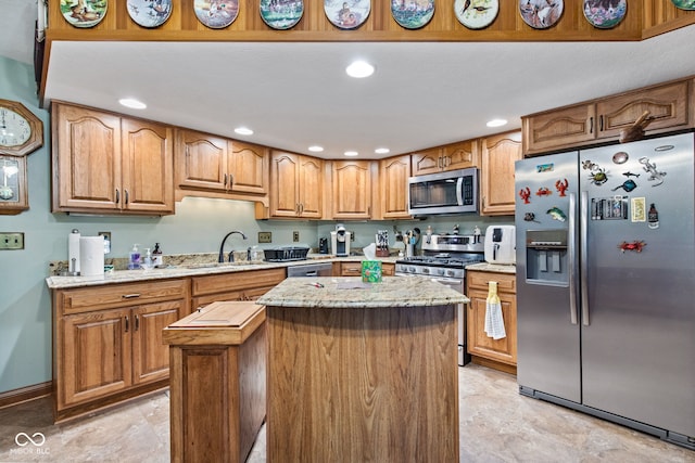 6980 White Oak Dr, Avon, IN 46123 - kitchen featuring appliances with stainless steel finishes, a center island, light stone counters, brown cabinetry, and recessed lighting