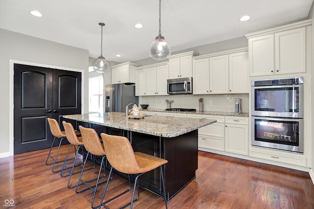 773 Bracknell Dr, Avon, IN 46123 - kitchen with appliances with stainless steel finishes, a center island with sink, a breakfast bar, white cabinetry, and recessed lighting