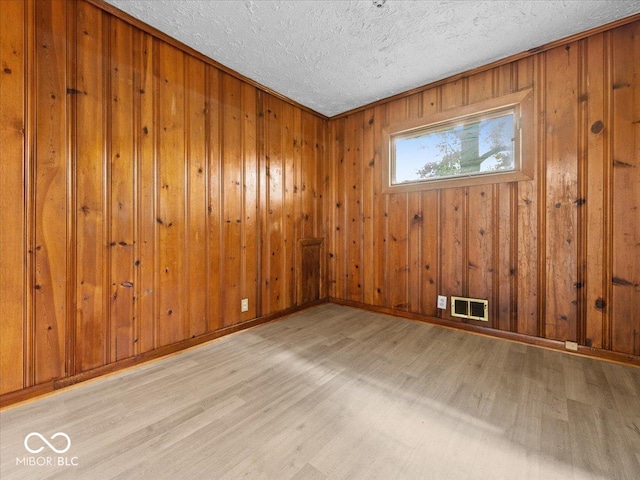 7422 E 33rd St, Indianapolis, IN 46226 - unfurnished room featuring wood finished floors, a textured ceiling, and wooden walls