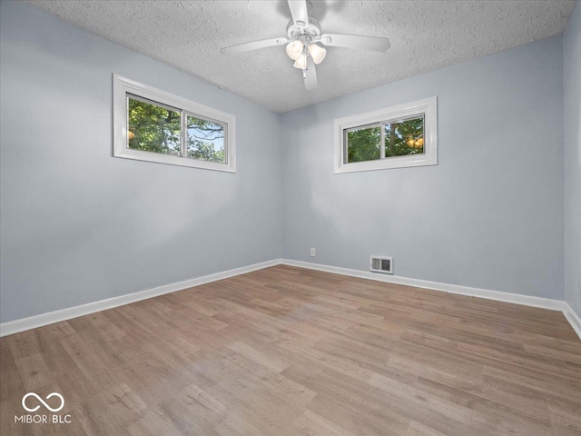 7422 E 33rd St, Indianapolis, IN 46226 - unfurnished room featuring healthy amount of natural light, light wood-style flooring, a ceiling fan, and a textured ceiling