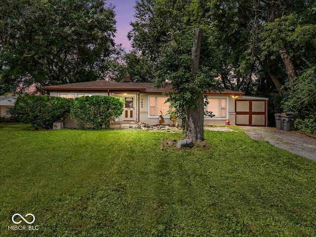 7422 E 33rd St, Indianapolis, IN 46226 - ranch-style house with driveway, a front yard, an attached garage, and stucco siding