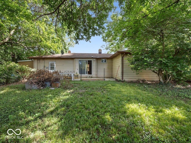 7422 E 33rd St, Indianapolis, IN 46226 - rear view of property featuring a chimney and a lawn