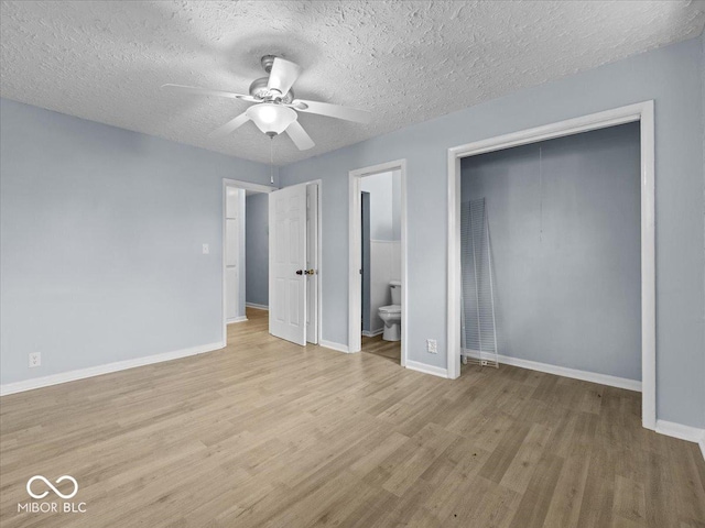 7422 E 33rd St, Indianapolis, IN 46226 - unfurnished bedroom with wood finished floors, a textured ceiling, connected bathroom, a closet, and a ceiling fan