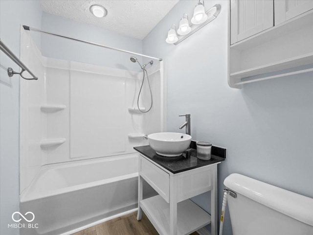 7422 E 33rd St, Indianapolis, IN 46226 - full bathroom featuring bathtub / shower combination, a textured ceiling, wood finished floors, and vanity