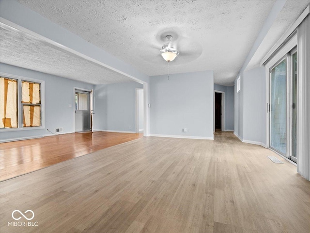 7422 E 33rd St, Indianapolis, IN 46226 - unfurnished living room with a ceiling fan, light wood-style flooring, and a textured ceiling