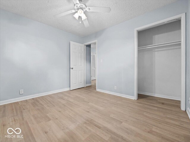 7422 E 33rd St, Indianapolis, IN 46226 - unfurnished bedroom featuring light wood-type flooring, a textured ceiling, a closet, and a ceiling fan