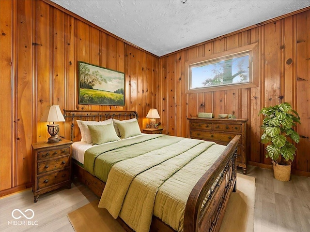 7422 E 33rd St, Indianapolis, IN 46226 - bedroom with wood walls, light wood-type flooring, and a textured ceiling