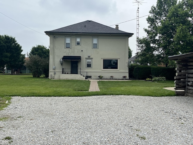1131 N Main St, Rushville, IN 46173 - back of property featuring stucco siding, a lawn, and a shingled roof