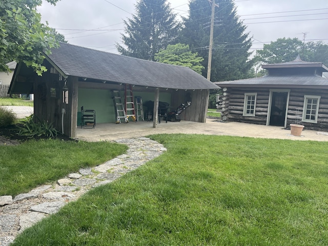 1131 N Main St, Rushville, IN 46173 - back of property with a yard, a patio area, log exterior, and an outbuilding