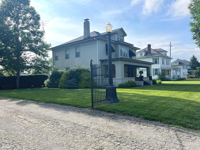 1131 N Main St, Rushville, IN 46173 - view of front of home featuring stucco siding, a front yard, and a chimney