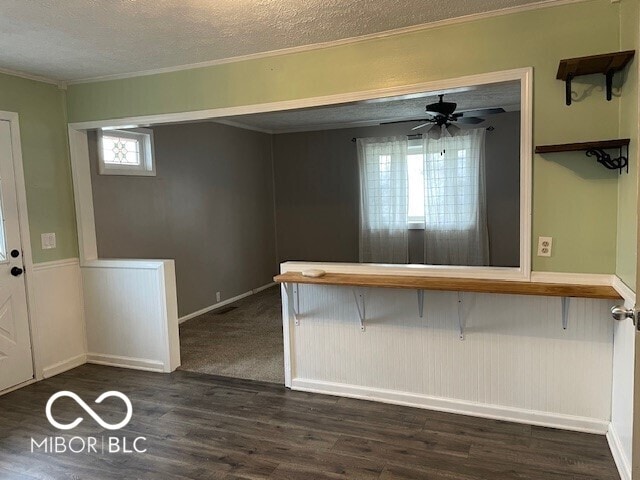 entryway featuring ornamental molding, dark wood-style flooring, a textured ceiling, and a ceiling fan