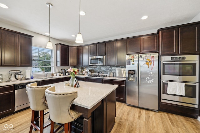 8126 Kilborn Way, Avon, IN 46123 - kitchen featuring appliances with stainless steel finishes, dark brown cabinetry, light stone counters, light wood-style flooring, and recessed lighting