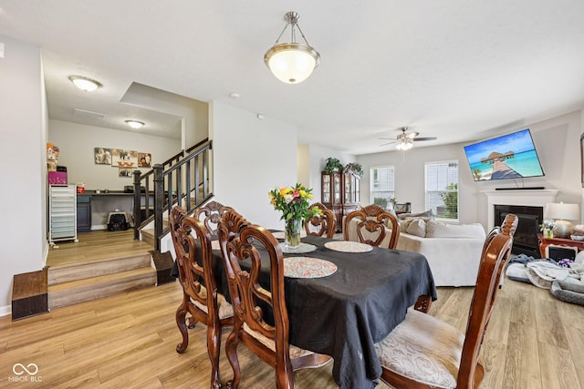 8126 Kilborn Way, Avon, IN 46123 - dining area featuring light wood-style floors, stairway, a ceiling fan, and a fireplace