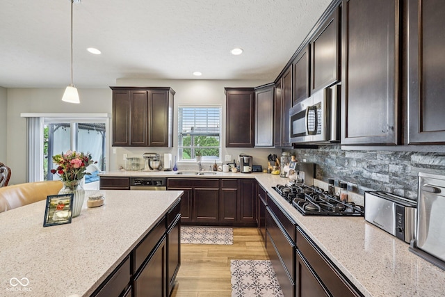 8126 Kilborn Way, Avon, IN 46123 - kitchen featuring stainless steel appliances, dark brown cabinetry, light wood-style flooring, recessed lighting, and pendant lighting
