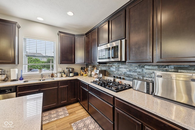 8126 Kilborn Way, Avon, IN 46123 - kitchen with stainless steel appliances, dark brown cabinetry, light wood-type flooring, light stone counters, and recessed lighting