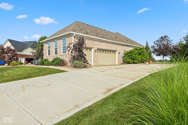 4434 Hickory Ridge Blvd, Greenwood, IN 46143 - view of side of property featuring brick siding, a lawn, an attached garage, concrete driveway, and a shingled roof