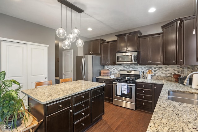 13992 Wynngate Ln, Fishers, IN 46038 - kitchen with stainless steel appliances, dark wood finished floors, decorative backsplash, a kitchen island, and recessed lighting
