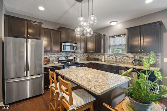 13992 Wynngate Ln, Fishers, IN 46038 - kitchen with stainless steel appliances, dark brown cabinetry, light stone counters, dark wood-style floors, and recessed lighting