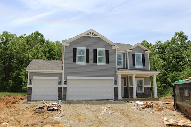1006 E Brandy Blvd E, Ellettsville, IN 47429 - view of front of home with stone siding, roof with shingles, driveway, a garage, and covered porch