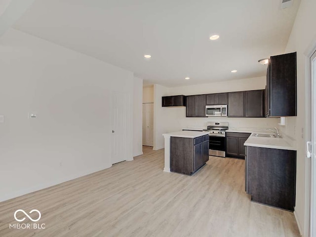 1006 E Brandy Blvd E, Ellettsville, IN 47429 - kitchen featuring appliances with stainless steel finishes, light wood-type flooring, a center island, dark brown cabinets, and light countertops
