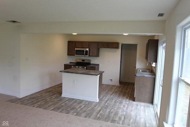 1029 E Brandy Blvd E, Ellettsville, IN 47429 - kitchen featuring appliances with stainless steel finishes, light wood-style flooring, dark countertops, and a kitchen island