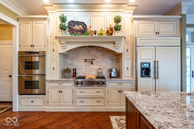 4636 S Hawks Way, Bloomington, IN 47401 - kitchen with appliances with stainless steel finishes, dark wood-style flooring, cream cabinetry, light stone countertops, and crown molding