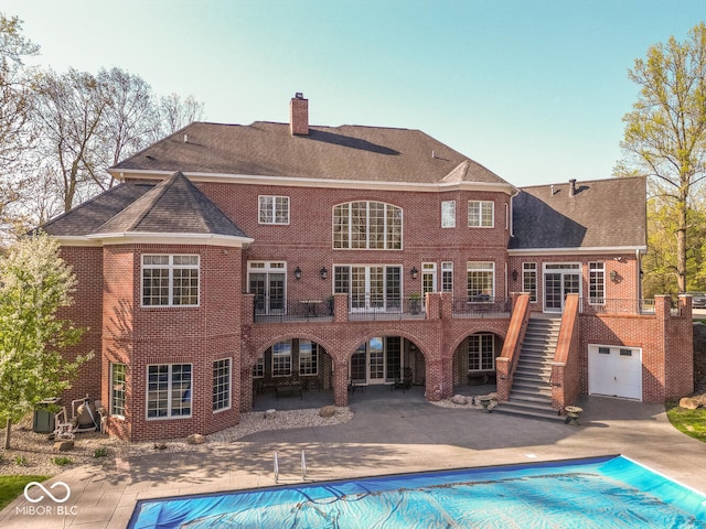 4636 S Hawks Way, Bloomington, IN 47401 - back of house featuring stairway, a chimney, a covered pool, brick siding, and a patio area