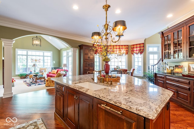 4636 S Hawks Way, Bloomington, IN 47401 - kitchen featuring arched walkways, a chandelier, ornate columns, open floor plan, and crown molding