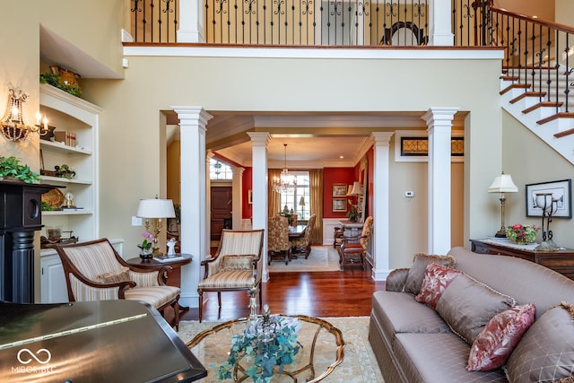 4636 S Hawks Way, Bloomington, IN 47401 - living area featuring a chandelier, wood finished floors, decorative columns, a towering ceiling, and stairway