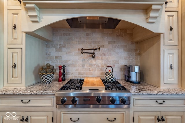4636 S Hawks Way, Bloomington, IN 47401 - kitchen with stainless steel gas cooktop, backsplash, and light stone countertops