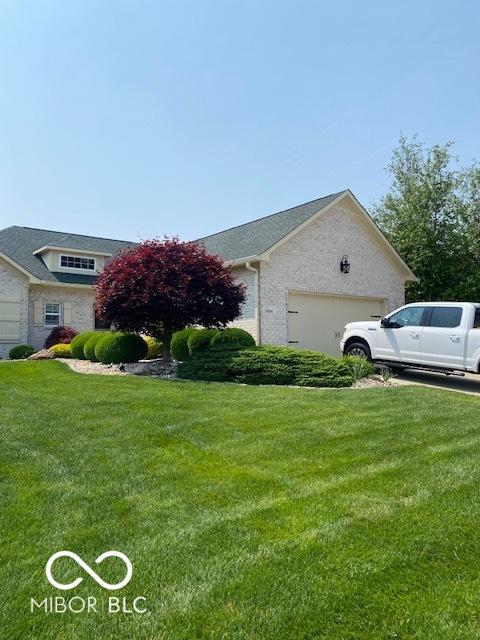 3354 Nottinghill Dr, Plainfield, IN 46168 - view of side of home featuring a garage, a lawn, and brick siding