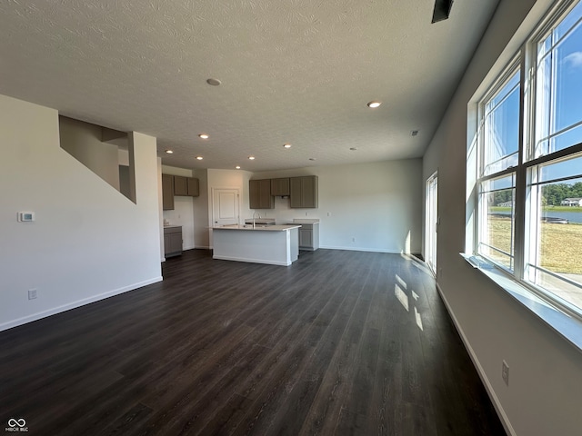 7909 Magnolia St, New Palestine, IN 46163 - unfurnished living room featuring dark wood-type flooring, recessed lighting, and a textured ceiling