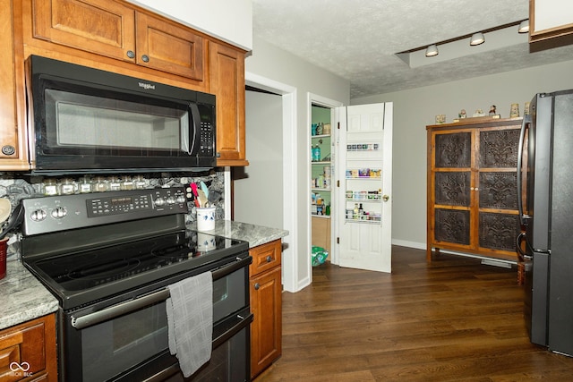13 Fairlane Dr, Brownsburg, IN 46112 - kitchen featuring black appliances, brown cabinetry, a textured ceiling, dark wood-style floors, and light stone countertops