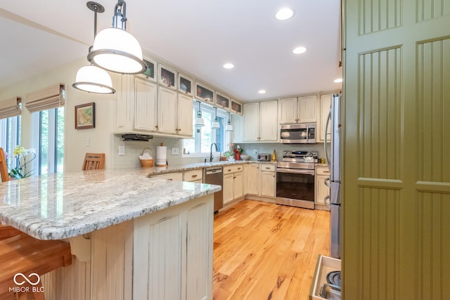 2608 S Trotters Run, Bloomington, IN 47401 - kitchen with stainless steel appliances, a peninsula, light wood finished floors, recessed lighting, and glass insert cabinets