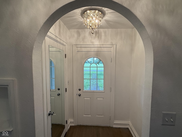 2607 N Henderson Rd, Rushville, IN 46173 - entrance foyer featuring dark wood-type flooring, a chandelier, arched walkways, and a textured wall