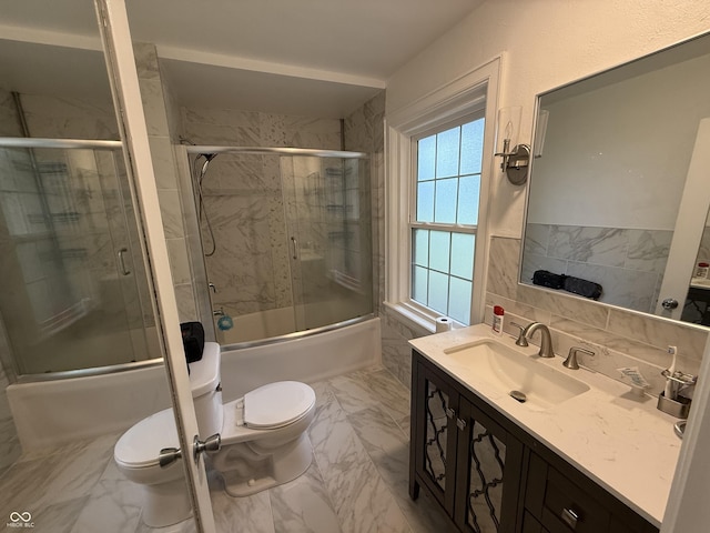 2607 N Henderson Rd, Rushville, IN 46173 - bathroom with marble look tiles, vanity, enclosed tub / shower combo, tile walls, and a wainscoted wall