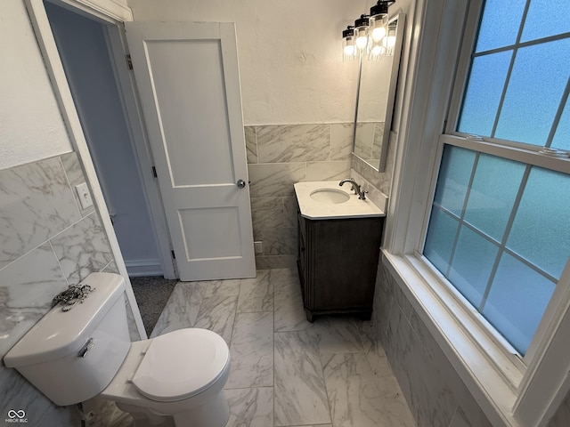 2607 N Henderson Rd, Rushville, IN 46173 - bathroom with tile walls, vanity, marble look tile flooring, and wainscoting