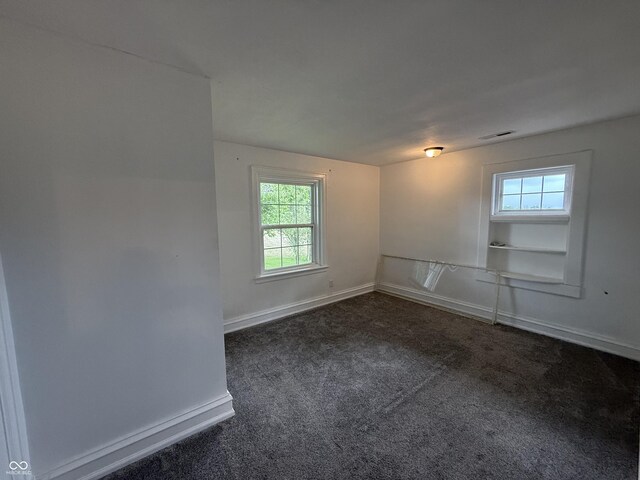 2607 N Henderson Rd, Rushville, IN 46173 - empty room featuring dark colored carpet and baseboards